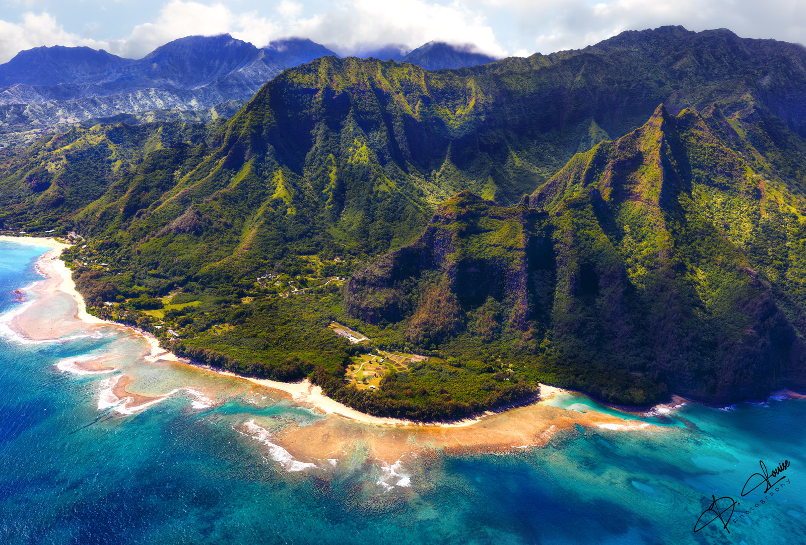 Sweeping aerial views approaching the Maniniholo Bay, The Kalalau trailhead to the right of the beach, the gorgeous Ke’e Beach...